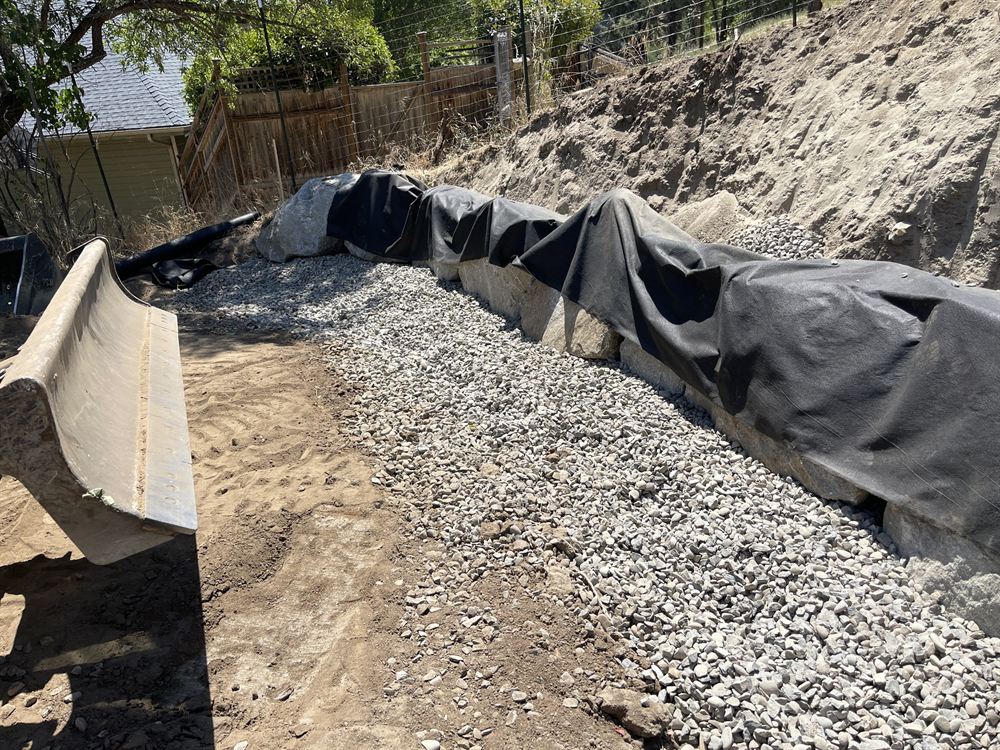 Boulder and rock work with drainage gravel forming a natural water feature
