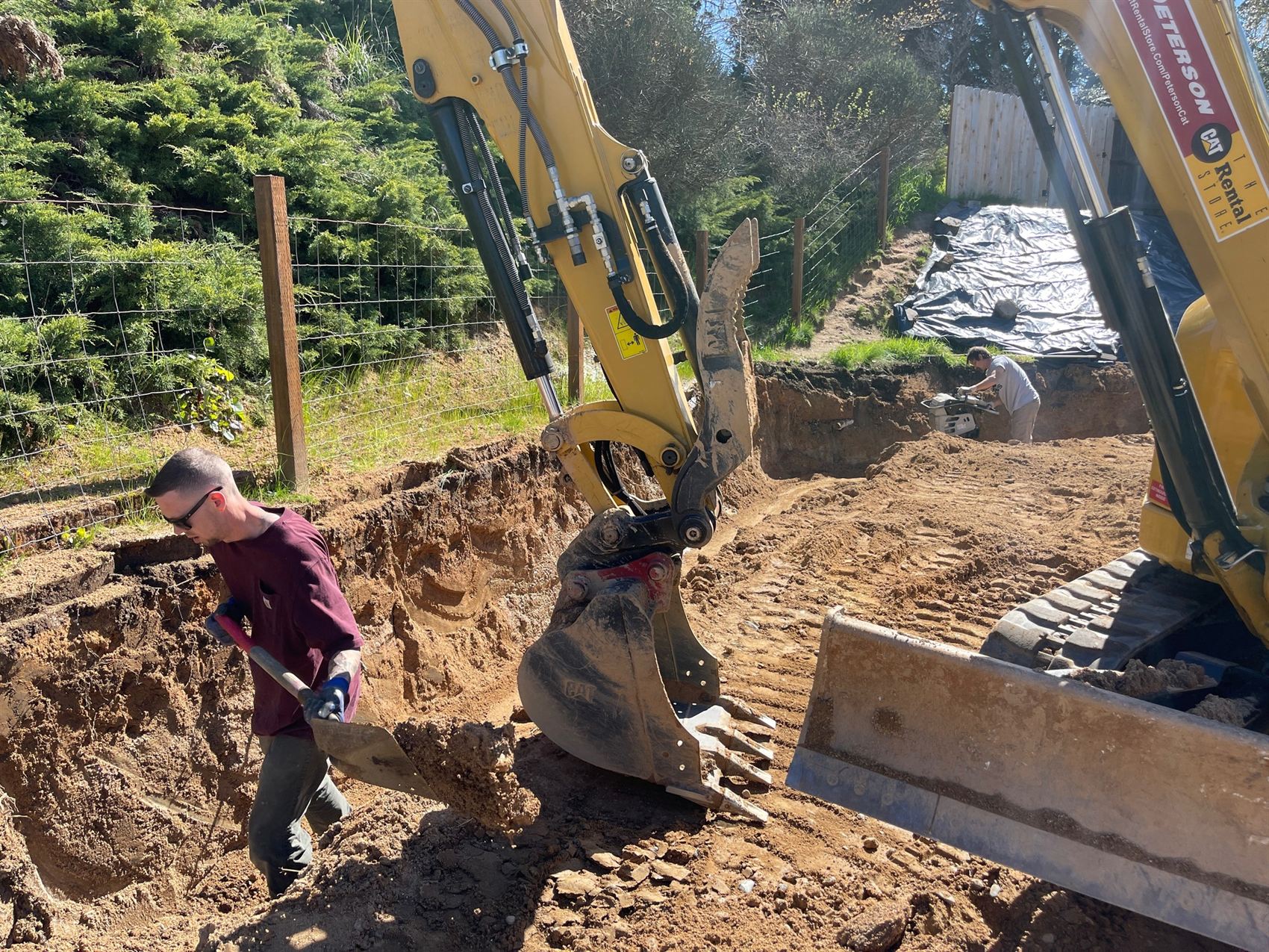 Pacific Earthworks crew operating a CAT excavator during a hillside dig in the Rogue Valley