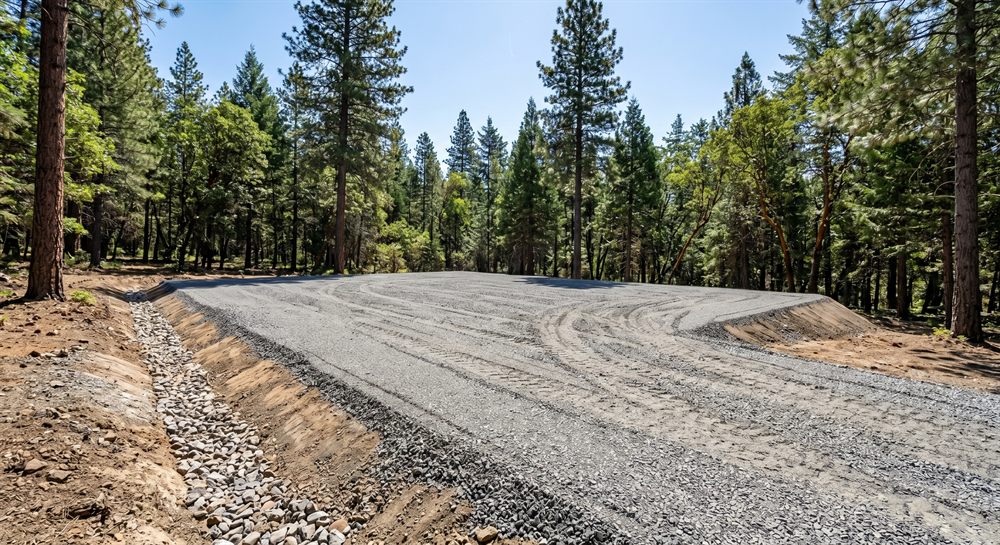 Compacted gravel building pad and drainage swale prepared in Southern Oregon