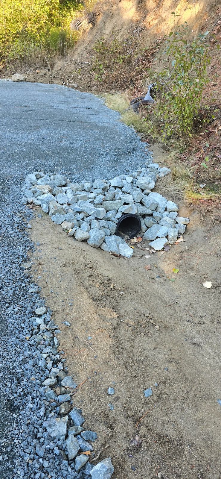 Rock rip-rap armoring around a culvert inlet protecting a graded driveway from washout and erosion, Southern Oregon