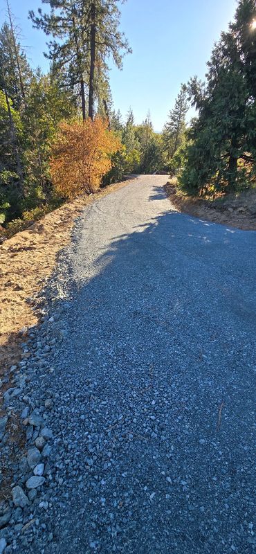 Finished crushed-gravel driveway with a clean rock-lined shoulder graded to shed water, Southern Oregon