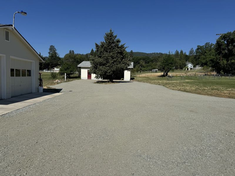 Wide finished gravel driveway and parking apron beside a garage on a rural Southern Oregon property