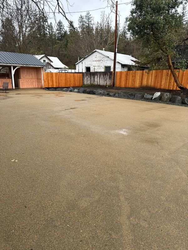 Completed commercial site prep with decomposed-granite parking, rock border and new cedar fence at Apple Outlaw Taproom in Jacksonville, Oregon