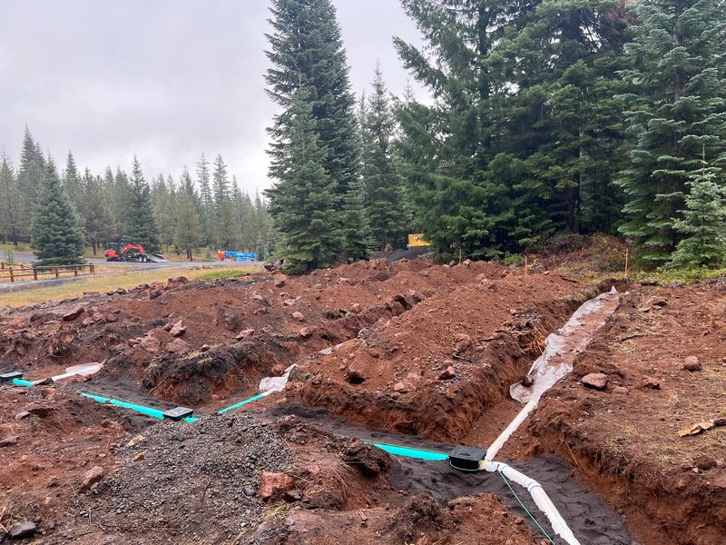 Septic drainfield trenches with distribution boxes and supply line on a forested mountain property at 5,200 feet in Southern Oregon