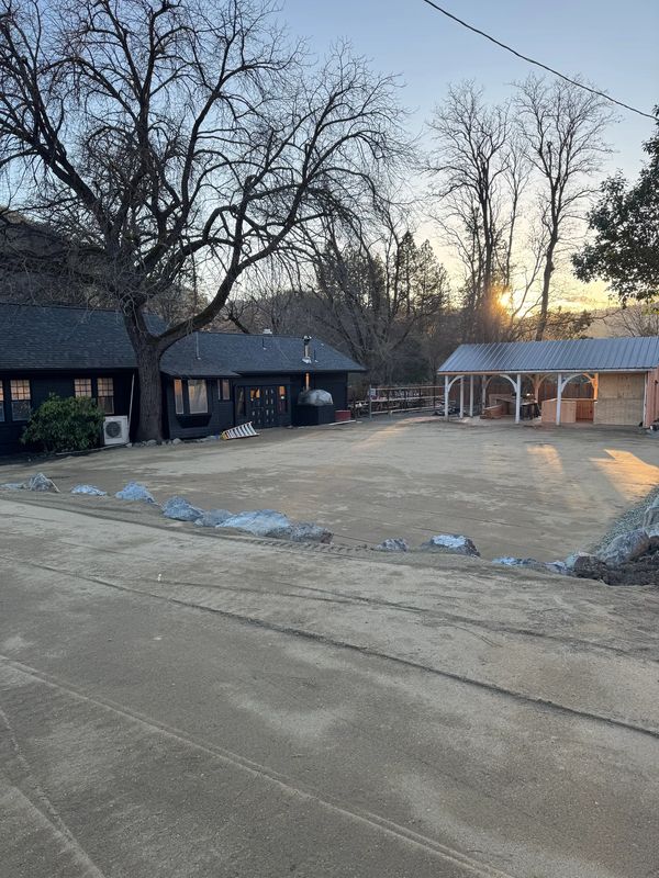 Near-finished decomposed-granite event area at dusk beside a newly built pavilion in Jacksonville, Oregon