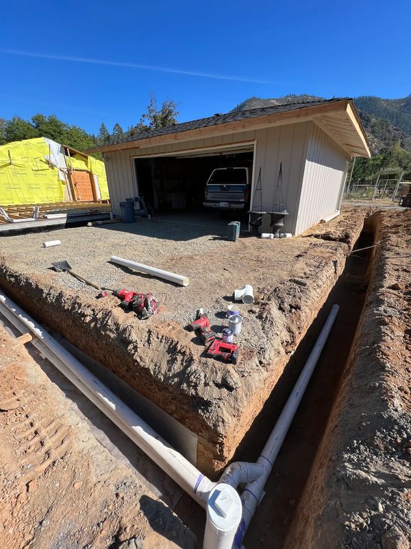 Underground plumbing and utility trenching around a new shop foundation on an Applegate Valley custom build in Southern Oregon