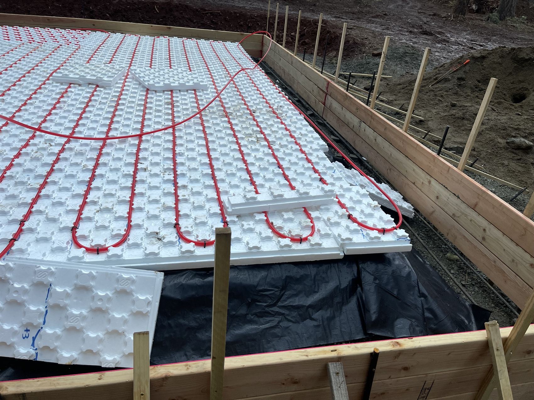 Radiant in-floor heating tubing on insulation before a barndominium slab pour
