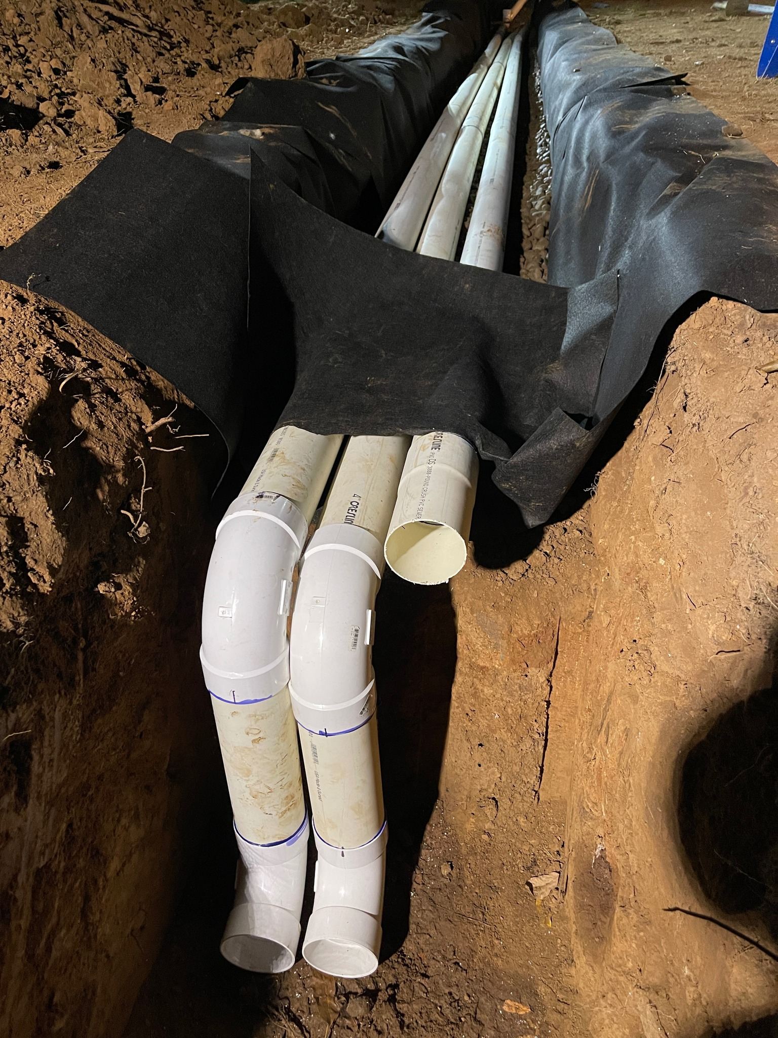Underground septic and sewer PVC pipe laid in a trench with filter fabric in the Rogue Valley